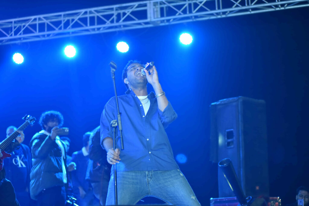 Vocalist performing on a blue-lit stage